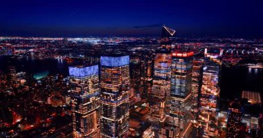 Pencereleri açık olan muhteşem gökdelenler. Geceleri ABD, New York 'un göz kamaştırıcı manzarası. Hava görünümü.