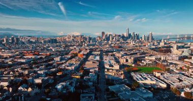 San Francisco 'nun yoğun kentsel manzarası batan güneşle aydınlanıyor. İHA görüntüleri şehrin muhteşem şehir merkezine yüksek binalı mimarisiyle yaklaşıyor..