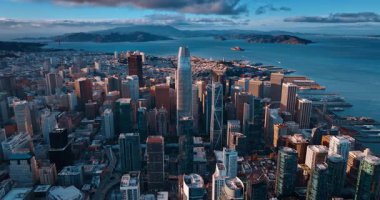 Batan güneş ışınları San Francisco, California, ABD 'deki en yüksek binaları aydınlatıyor. Koyun üzerinde kara bulutlar asılı.