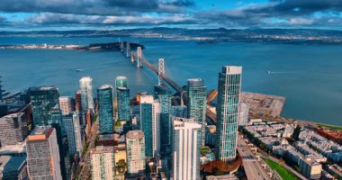 Oakland Bay Köprüsü 'nün girişine yoğun bir trafik ile yaklaşıyoruz. Mavi sularda çok az gemi var. Kabarık siyah bulutlar gökyüzünde.