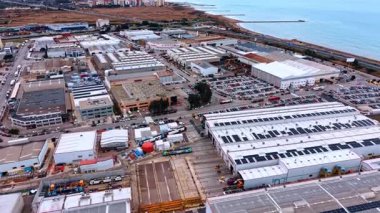 Alicante, İspanya, 8 Şubat 2026: Lojistik merkezi ve kıyı sanayii. Deniz kıyısı yakınında trenler, kamyonlar, depoları ve güneş panelleri olan geniş bir sanayi bölgesi..