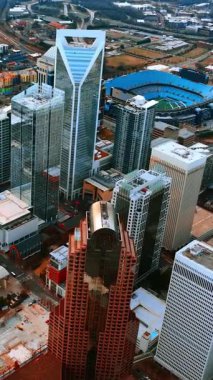 Charlotte, NC, ABD 'nin canlı modern şehir merkezine hava perspektifi. İnsansız hava aracından şehrin binalarını ve caddelerini izleyin. Dikey video