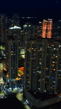 Gece şehir manzarası inanılmaz, Miami, Florida 'nın ışıltılı manzarası, ABD tepeden. Dikey video