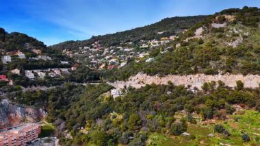 Dağ yamacında inşa edilmiş otobana yaklaşıyoruz. Yeşillik kayaların üzerinde sayısız villa bulunmaktadır. Güzel, France. Hava görünümü.