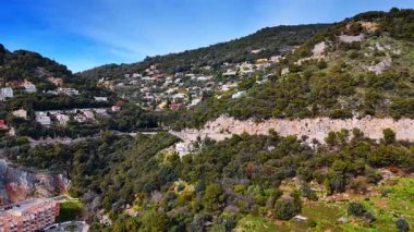 Dağ yamacındaki yol arabalarla kesişiyor. Nice, Fransa manzaralı yeşil kayaların yamaçlarında. Hava görünümü.