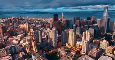 Batan güneş, San Francisco, California, ABD şehir merkezinin manzarasını aydınlatıyor. Arka planda koyu dramatik gökyüzü manzarası. Hava görünümü.