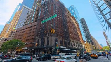 New York, ABD, 9 Ağustos 2025: Şebeke pencereli ve yeşil ağaçlı modern ofis binası cephesi.