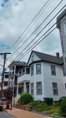 Boston mahallesinde geleneksel olarak üç katlı bir apartman dairesi. Elektrik hatları ve elektrik direğinin altında yan yatmış çok aile ahşap evleri var..