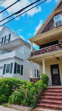 Taş duvarı ve kapısı olan mavi ahşap kiremitli ev. Mavi sedir kiremitleri, taş temeli ve siyah metal giriş kapısı olan bir ev..