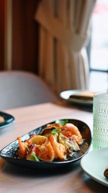 Karides midyeli ve beyaz şarap kadehli gurme deniz ürünleri salatası. Karides, midye, ahtapot ve beyaz şarap ile somon yumurtası içeren siyah tabakta karışık deniz ürünleri aperatifleri..