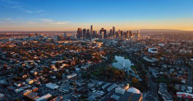 Batan güneşin aydınlattığı şehrin yukarısına gidiyorum. Şehir merkezindeki gökdelen grubunun görüntüsü. Los Angeles, Kaliforniya, ABD.