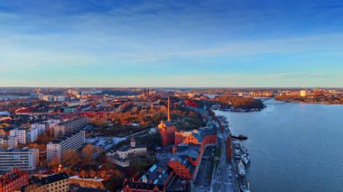 Gün batımında İsveç, Stockholm rıhtımında. Rıhtımda bir sürü tekne duruyor..