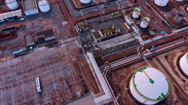 Bir kimya fabrikasının büyük sanayi bölgesinde uçuş. Yakıt depolama için çeşitli boyutlardaki beyaz tankları görüntüle.