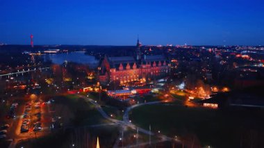 Parkın üzerinde gece park yeri olan bir kamera görüntüsü. Stockholm, İsveç 'teki Curgarden adasındaki İskandinav Müzesi' nin güzel binasına bakın..