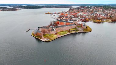 Vaxholmen Adası 'ndaki Vaxholm Kalesi' nin tuğla duvarlarına yaklaşıyoruz. Sıkıcı bir günde İsveç, Stockholm takımadalarının manzarasına bakın..