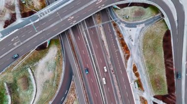 Otoyollar, döner kavşaklar ve hareket eden arabalar. Şehirdeki yollar sistemi. Yollar karla kaplı. Üst görünüm.
