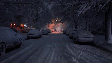 Kışın karlı gece yürüyüşü. Kalın kar tabakasıyla kaplı güzel ağaçlar ve arabalar boyunca yumuşak karlarla kaplı yolda ilerlerken.