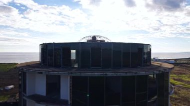 Silindirik, yüksek katlı, koyu camlı bir bina etrafında uçmak. Üstteki kubbenin çerçevesi. Tamamlanmamış yapı.