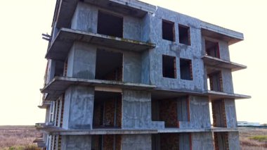 Alçıyla kaplı yüksek katlı tuğla bina boyunca yükseliyor. Alandaki tamamlanmamış yapı.