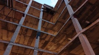 Gelecekteki binanın çerçevesinde yükseliyor. Metal demirler en üstte. İnşaat konsepti.