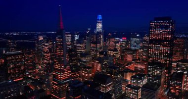 San Francisco, California, ABD 'nin göz kamaştırıcı yüksek binalarının tepesindeki görüntüler. Transamerica Piramidi yakınlarında gece uçuşu.