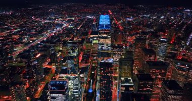 Şehir merkezindeki gökdelende mavi neon tepeli Satış Gücü Kulesi. İHA 'dan Metropolis' in gece panoraması.