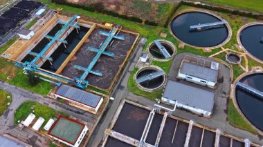 Tedavi merkezindeki hava tanklarının yüksek açılı görüntüsü. Dikdörtgen havacılık havzalarının detaylı hava görüntüsü ve su temizleme için hareket eden köprülerle birlikte dairesel netleştiriciler..