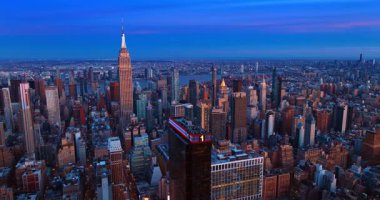 Gün batımında New York 'un ikonik manzarası. Parlak batan güneş ünlü Empire State binasını aydınlatıyor..