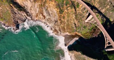 Bixby Creek Köprüsü 'nün yukarıdan aşağı görüntüsü. Büyük Sur 'daki Bixby Köprüsü' nün kayalık kıyı ve turkuaz Pasifik Okyanusu üzerindeki dikey aşağı manzarası.