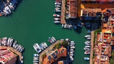 Lüks yatları olan marina limanı manzarası. Gemiler İspanya 'da çatısı güneş panelli binaların yanındaki berrak suya yanaştı..