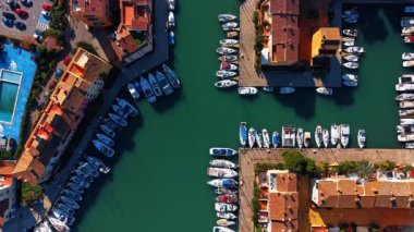 Saplaya Limanı 'nda yatlar. İspanya, Alboraya 'daki renkli iskan rıhtımları arasında zümrüt suya demirlemiş beyaz teknelerin dikey görüntüsü.