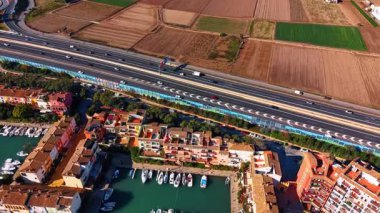 Saplaya Limanı 'ndaki otoyol ve renkli binalar. Akdeniz yerleşim alanı ve yat limanının yanındaki karayolu trafiğinin en üst görüntüsü..