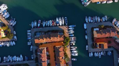 Yat limana demirlemişti. Saplaya Limanı 'nın mavi sularındaki sayısız beyaz tekne ve yatların yukarıdan görünüşü.
