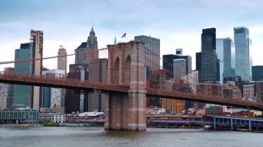 Gündüz vakti nehir manzarasından Brooklyn Köprüsü 'ne. New York 'un modern ufuk çizgisi alçak perspektiften arka planda.