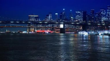 Gece vakti nehrin yüzeyine doğru ilerliyoruz. Manhattan Köprüsü 'ne ve New York' un aydınlık siluetine yaklaşıyoruz..