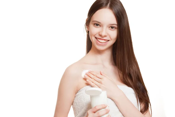 Young brunette using body lotion. — Stock Photo, Image