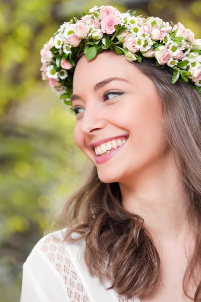 Wunderschöne brünette Frau trägt Frühlingsblumenkranz. — Stockfoto