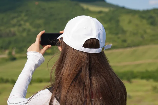 Brunette woman taking beautiful nature photo. — Stock Photo, Image