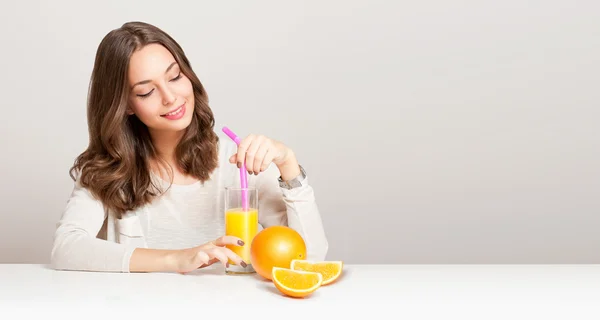 Ung brunett kvinna med apelsinjuice. — Stockfoto