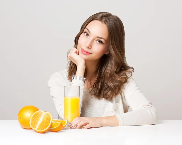 Ung brunett kvinna med apelsinjuice. — Stockfoto