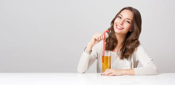 Joyeux jeune femme avec un verre de jus de fruits . — Photo