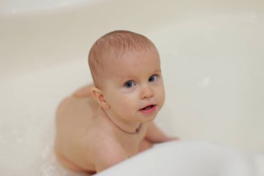 Mavi gözlü bebek bir yerlere bakıyor. Şu an banyoda.