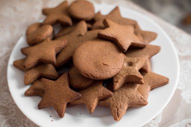 Yıldızlar şeklinde kahverengi zencefilli ekmek beyaz bir tabakta yığılır..