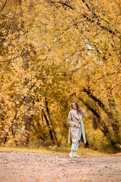 Caucasian Girl Pink Coat Blue Jeans Holes Dances Autumn Park — Stock Photo, Image