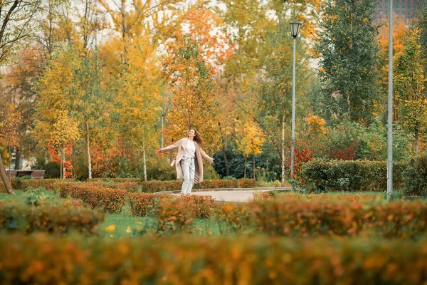 Caucasian Girl Pink Coat Blue Jeans Holes Dances Autumn Park — Stock Photo, Image