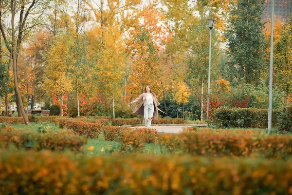 Caucasian Girl Pink Coat Blue Jeans Holes Dances Autumn Park — Stock Photo, Image