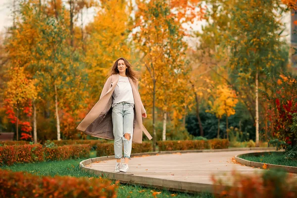 Caucasian Girl Pink Coat Blue Jeans Holes Dances Autumn Park — Stock Photo, Image
