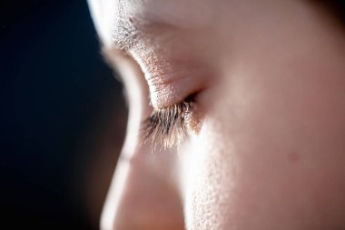 Uzun kirpikleri olan beyaz bir çocuğun kahverengi gözü. Kapat.