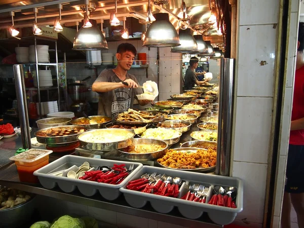 Un homme sert de la nourriture pour un client chez un colporteur dans la ville de Tampines à Singapour — Photo