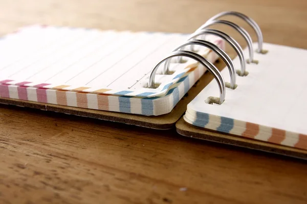 Colorful small spiral notebook on a wooden table — Stock Photo, Image